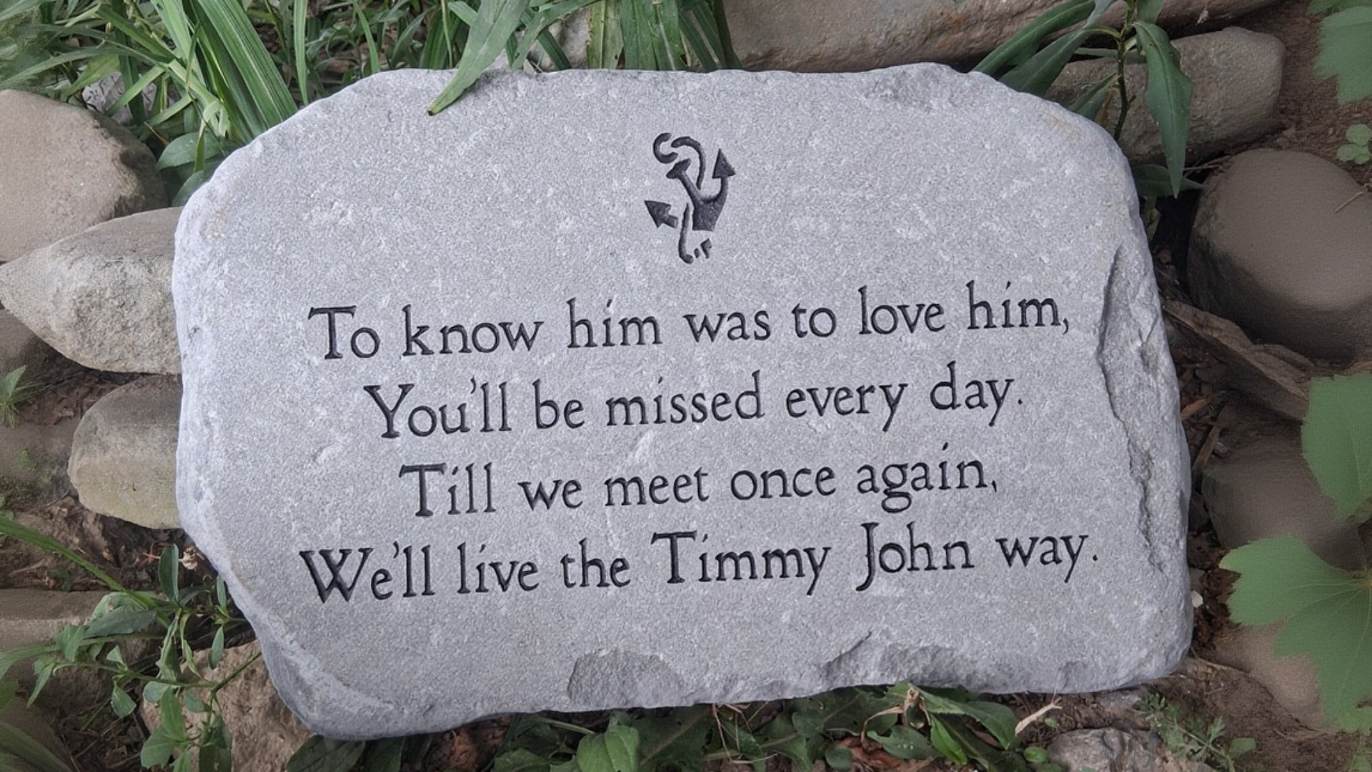 A rectangular bluestone memorial garden stone with engraved black text reading 'To know him was to love him.