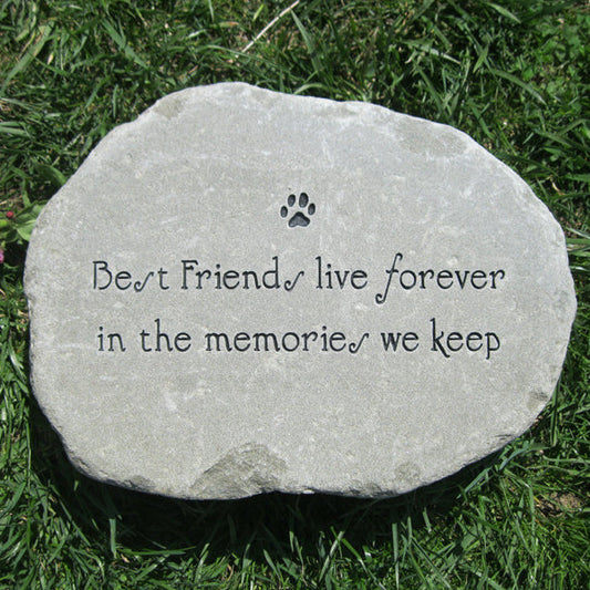 A round light gray memorial stone engraved with a paw print and the words 'Best Friends live forever in the memories we keep,' placed on green grass.